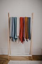 Lade das Bild in den Galerie-Viewer, Auf dem Bild sieht man neun Schals auf einer Kleiderstange hängend. Von links nach rechts sieht man die Farben Natur-grau, aschblau, Salbei-grün, creme, rot, lila-beere, Kupfer-braun und anthrazit. 
